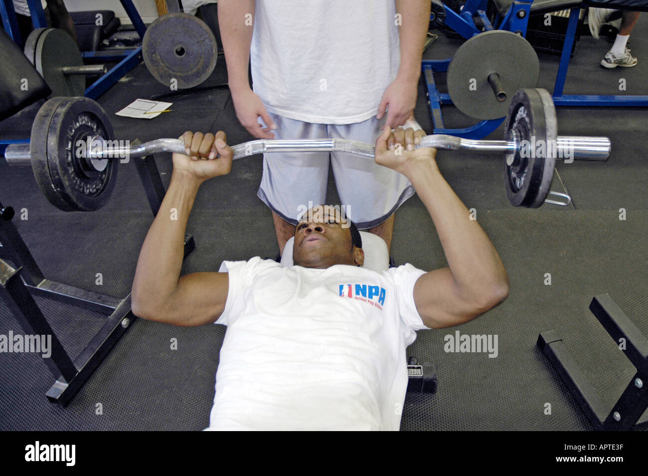 High school student lifts iron weights in a body building class Stock