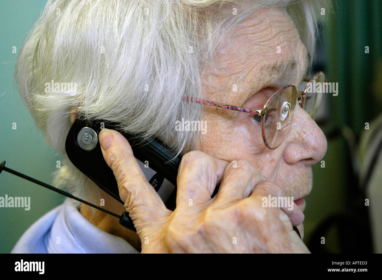 Senior female talks on a cell phone while rehabbing in a nursing home
