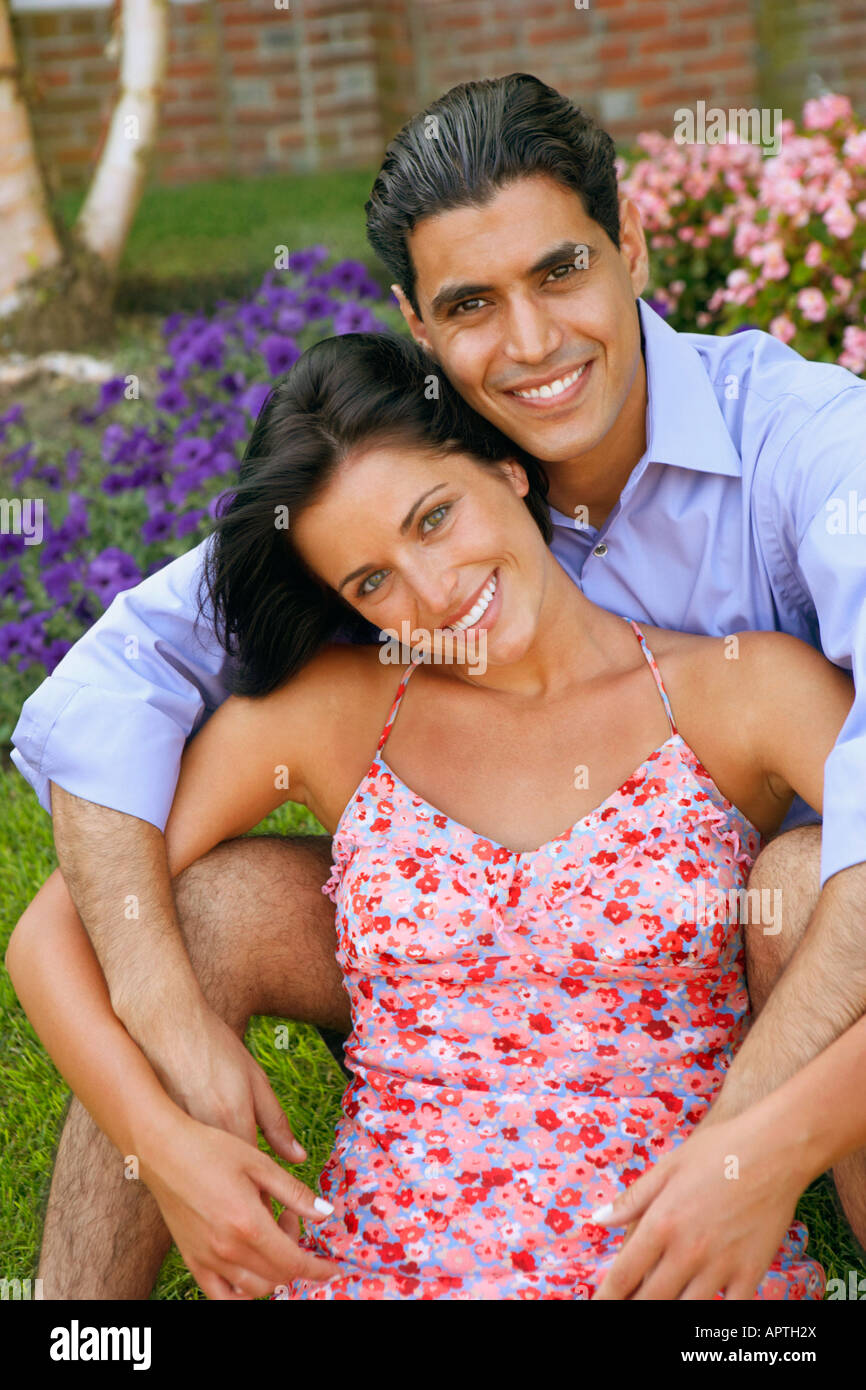 Young couple sitting in grass Stock Photo - Alamy