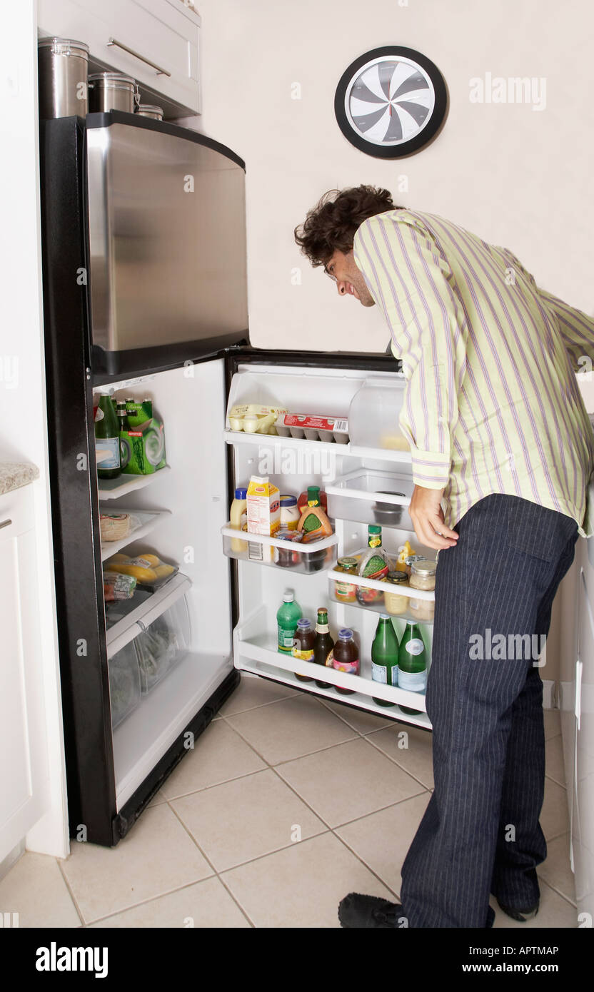 Hispanic man looking in refrigerator Stock Photo Alamy