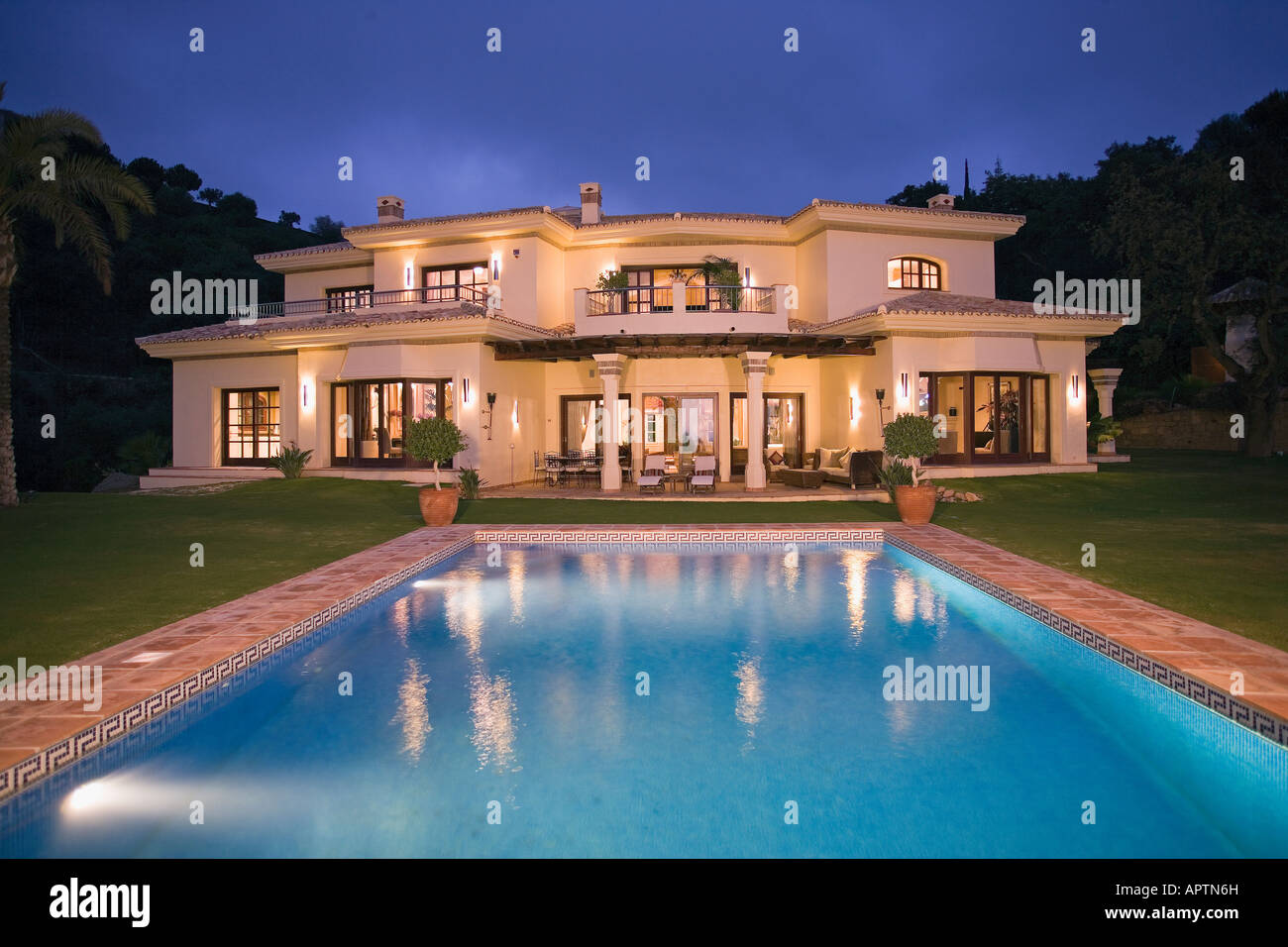 Modern Spanish villa with swimming pool, rear facade at dusk Stock