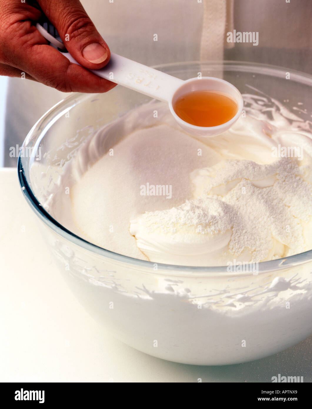 Steps to making pavlova adding white wine vinegar to whisked meringue