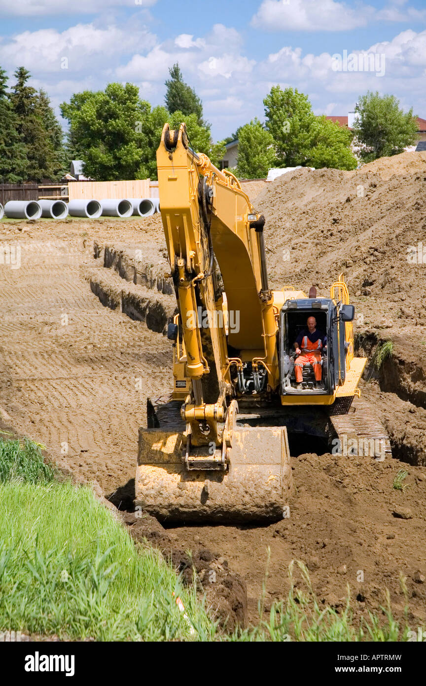 Backhoe digging a ditch for pipes Stock Photo Alamy