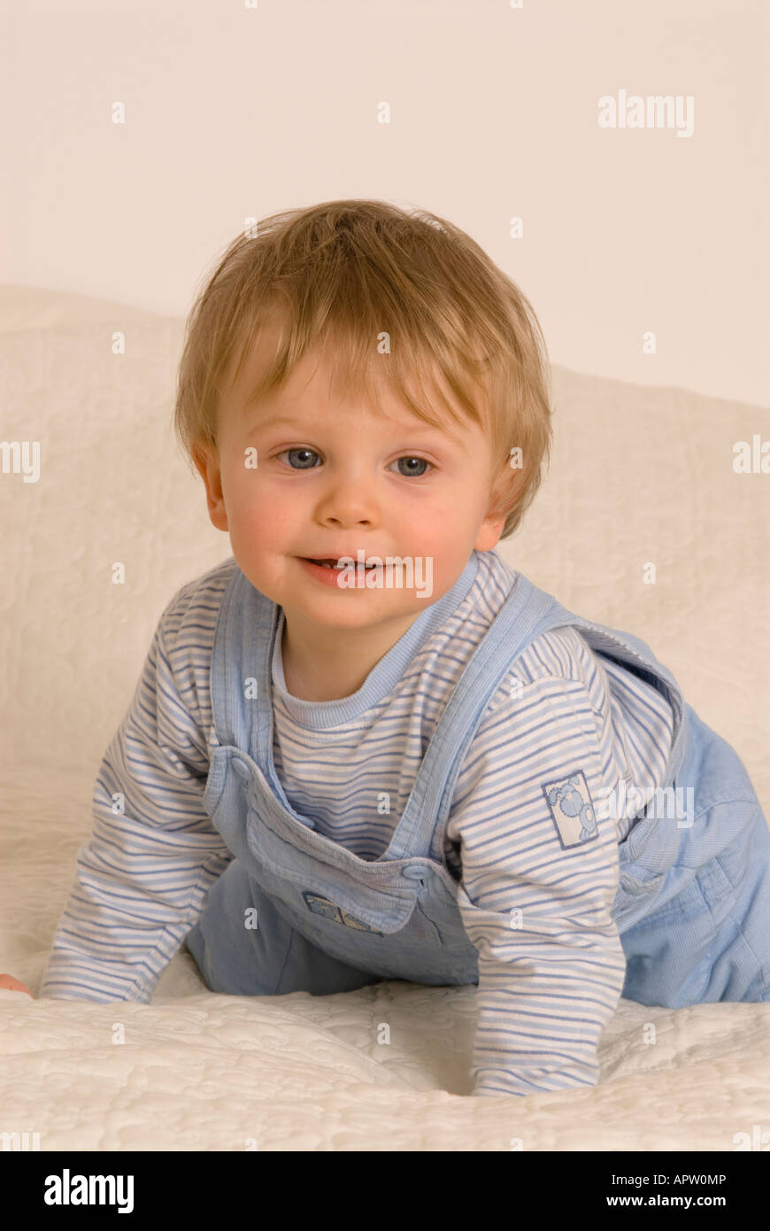 One year old baby boy on bed smiling Stock Photo Alamy