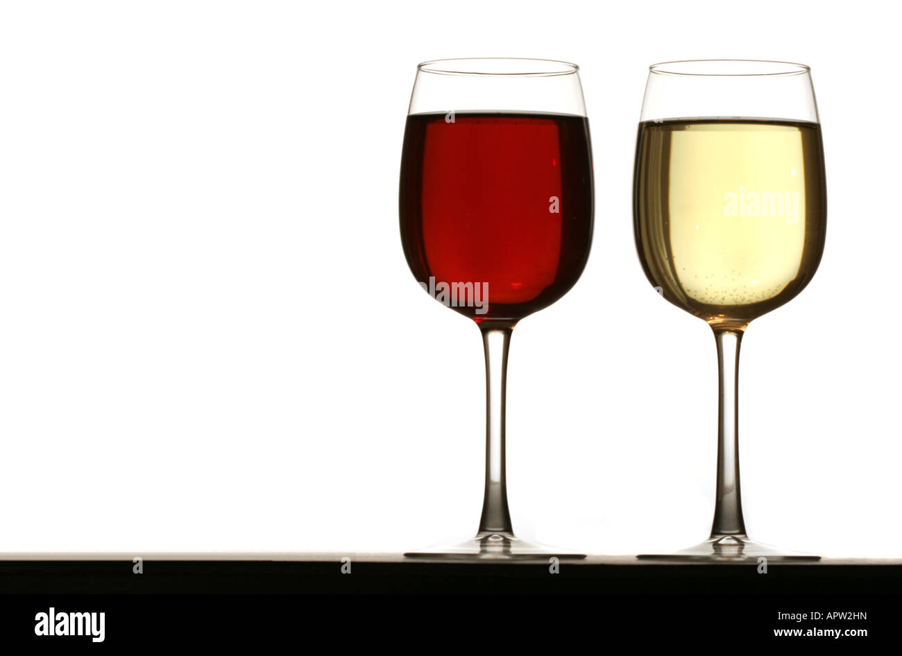 Glasses of red and white wine standing on table isolated on white ...