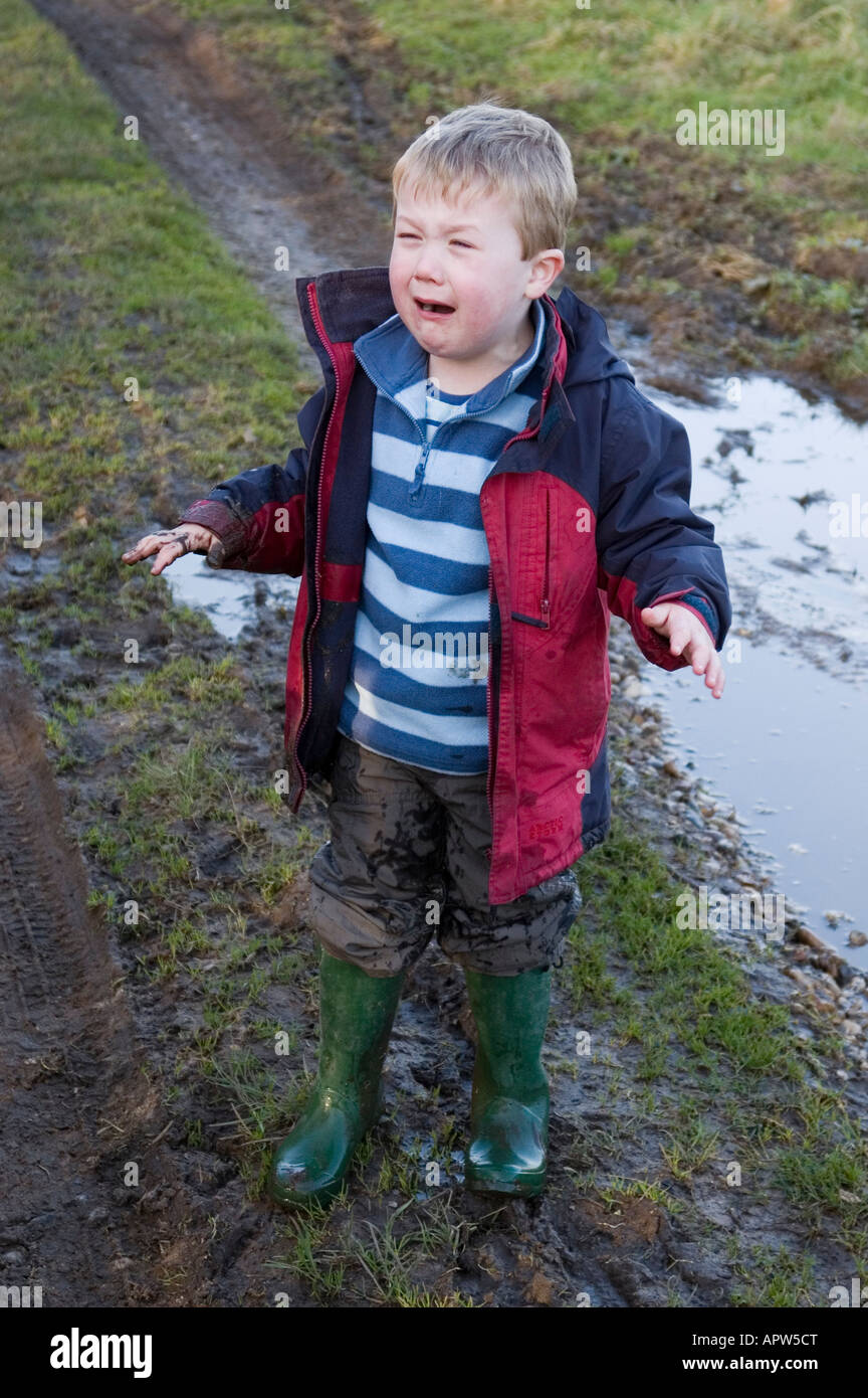 Four Year Old Boy Crying After Falling Over In Puddle in the uk countryside Stock Photo
