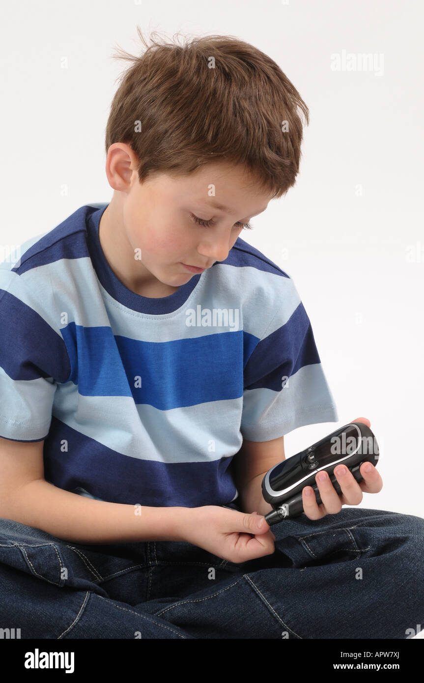 Young diabetic boy doing blood glucose level test. 2008 device Stock Photo