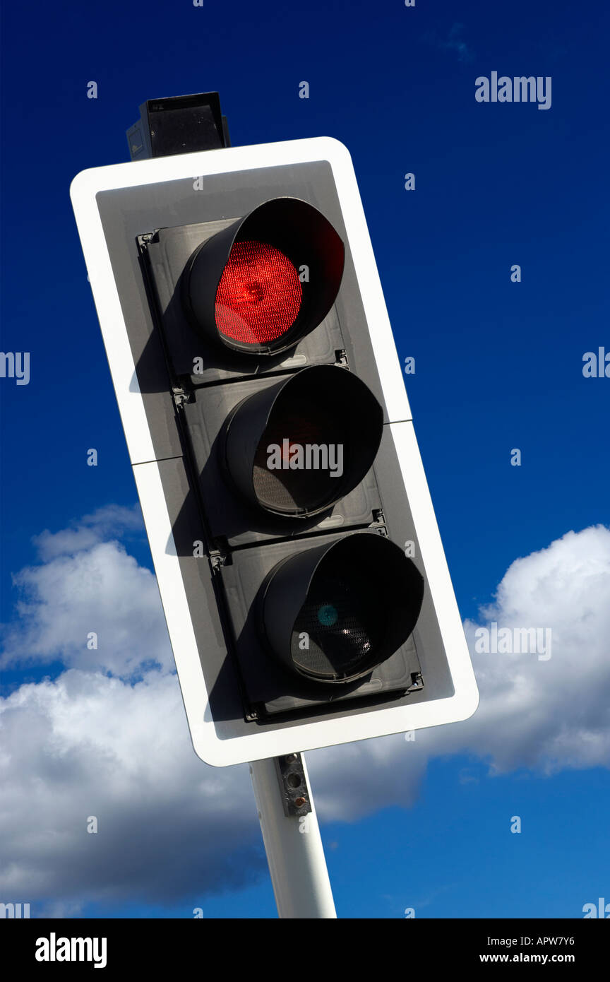 RED ROAD TRAFFIC LIGHT WITH BLUE SKY Stock Photo