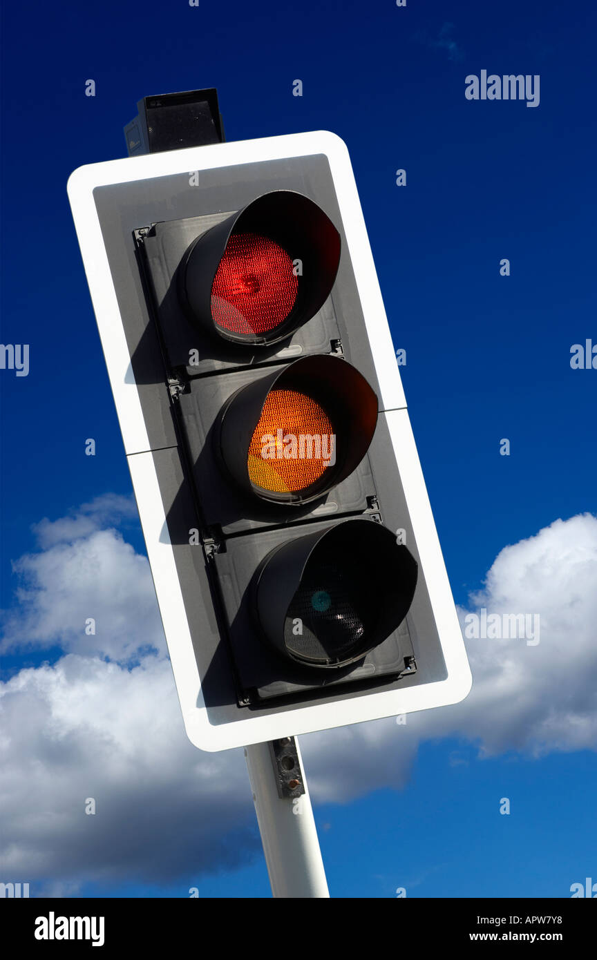 RED AND AMBER ROAD TRAFFIC LIGHT WITH BLUE SKY Stock Photo