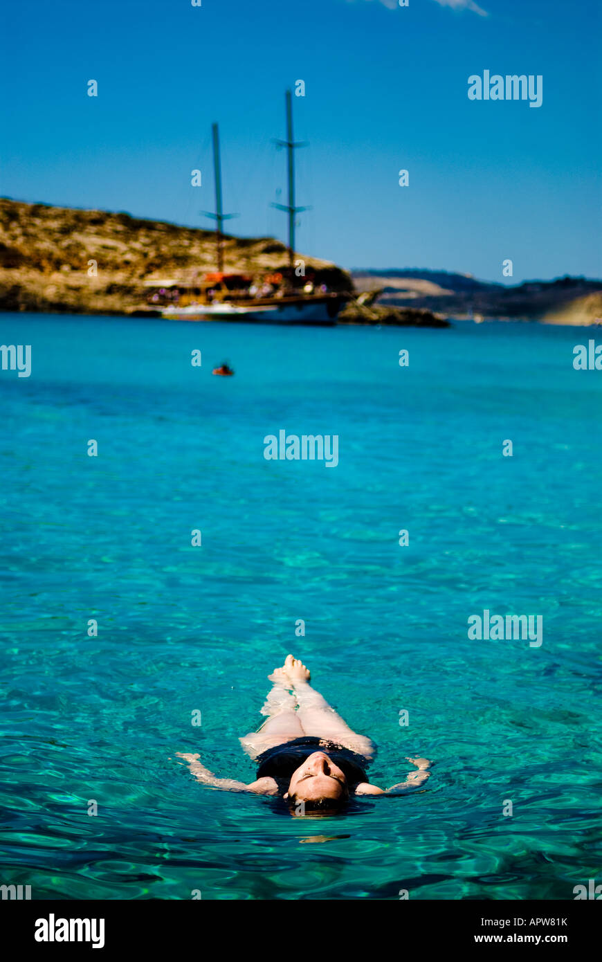 A lone woman floating in the sea Stock Photo
