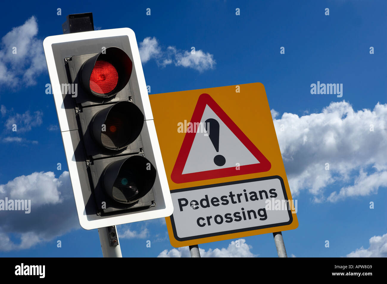 RED ROAD TRAFFIC LIGHT AND PREDESTRIAN CROSSING SIGN WITH BLUE SKY Stock Photo