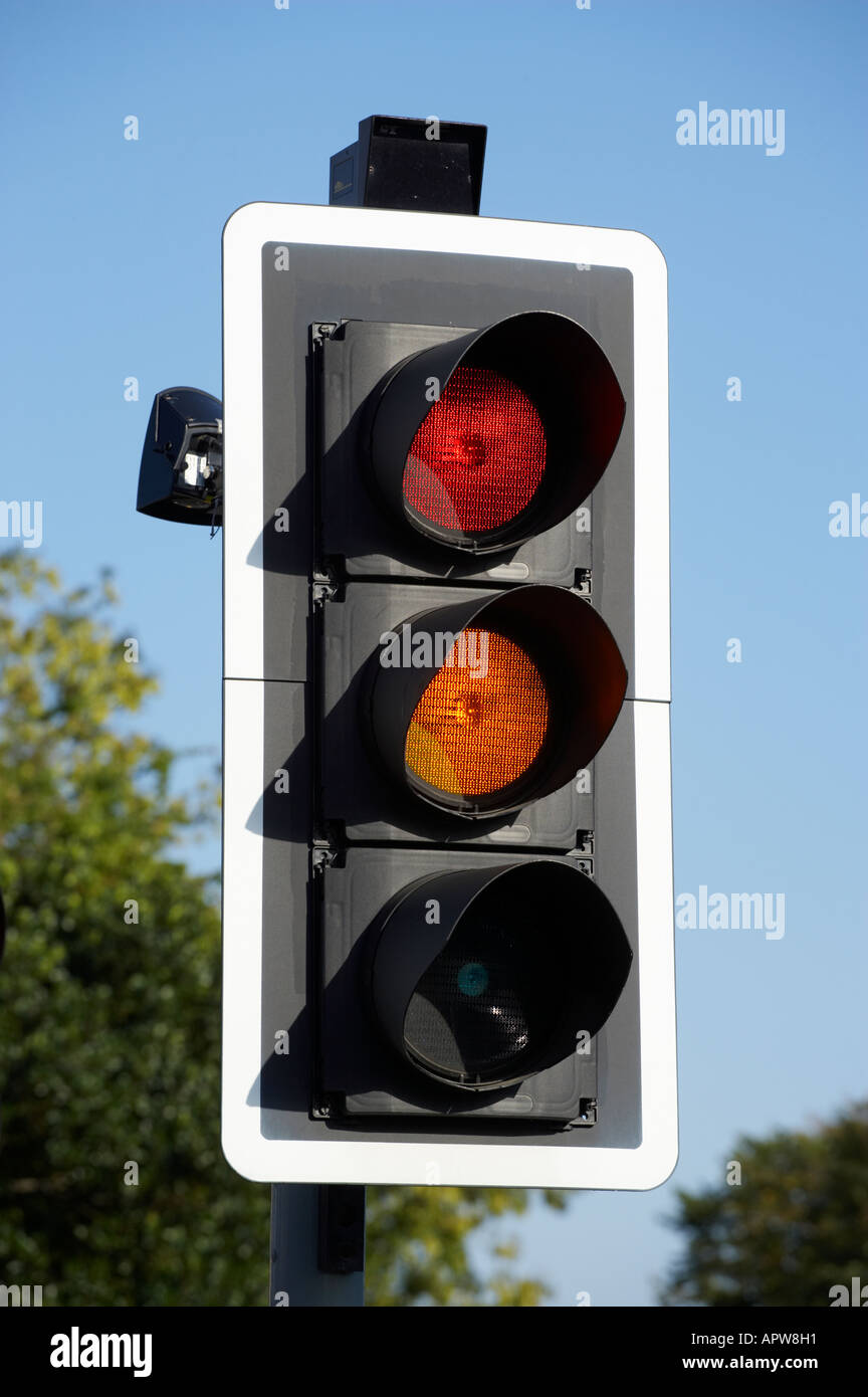 RED AND AMBER ROAD TRAFFIC LIGHT WITH BLUE SKY Stock Photo
