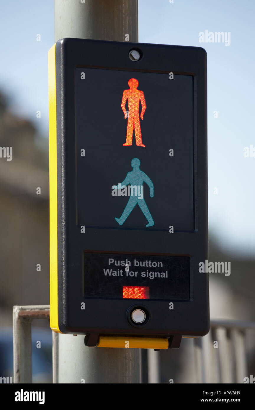 PEDESTRIAN CROSSING CONTROL BOX WITH ILLUMINATED RED MAN ICON AND BLUE SKY Stock Photo