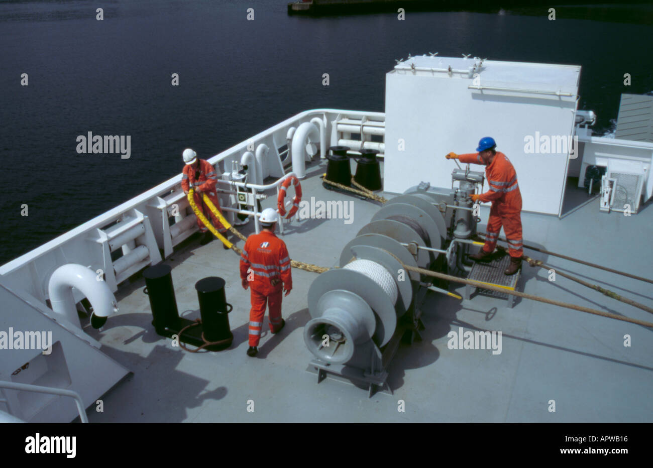 Crew operating a ship's winch on a ferry boat Stock Photo Alamy