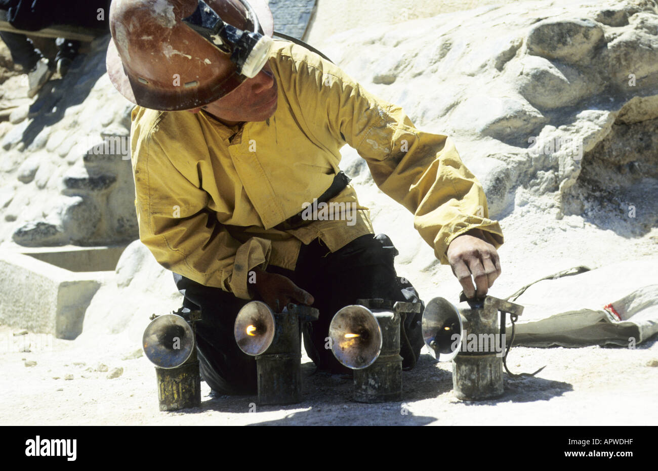 Miner ignites Davy lamps before entering the mines on Cerro Rico. Potosi, Bolivia Stock Photo