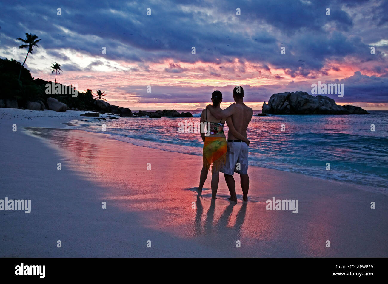 People on beach at sunset Model released Seychelles Cousine Island Stock Photo