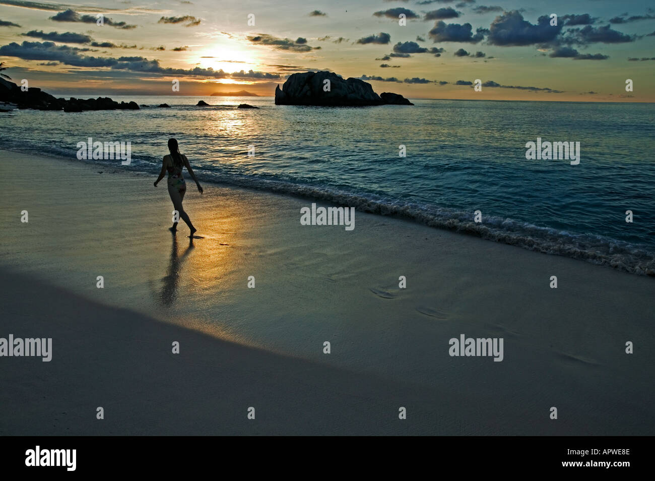 People on beach at sunset Model released Seychelles Cousine Island Stock Photo