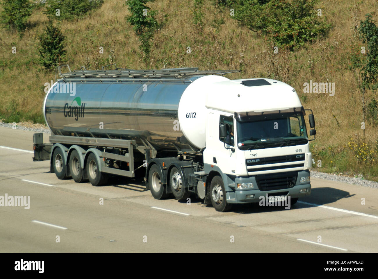 DAF lorry tyre saving economy raised axle towing articulated Cargill tanker trailer driving along UK English M25 motorway concrete road Stock Photo