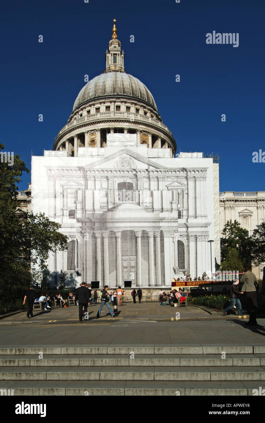 St Pauls cathedral during restoration work with scaffolding hidden by large painted trompe l'oeil façade blue sky day in City of London England UK Stock Photo