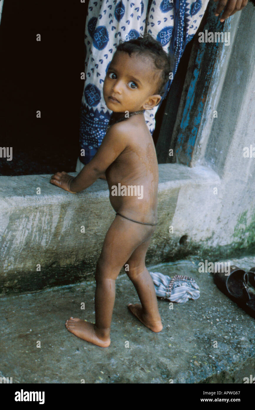tiny Indian baby standing by doorway Stock Photo