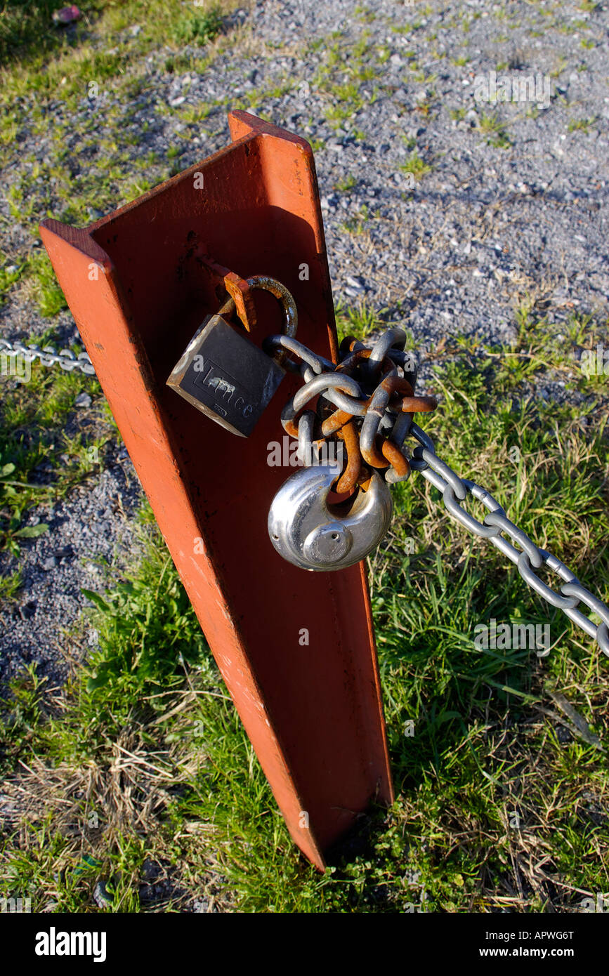 chain tied with padlock to a post of red iron Stock Photo