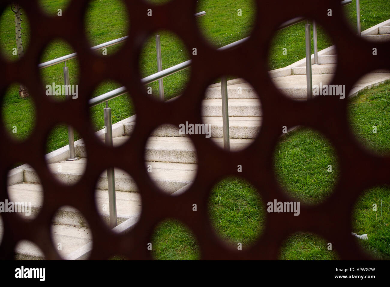 stairway with grass behind a blur grate of rusty iron Stock Photo