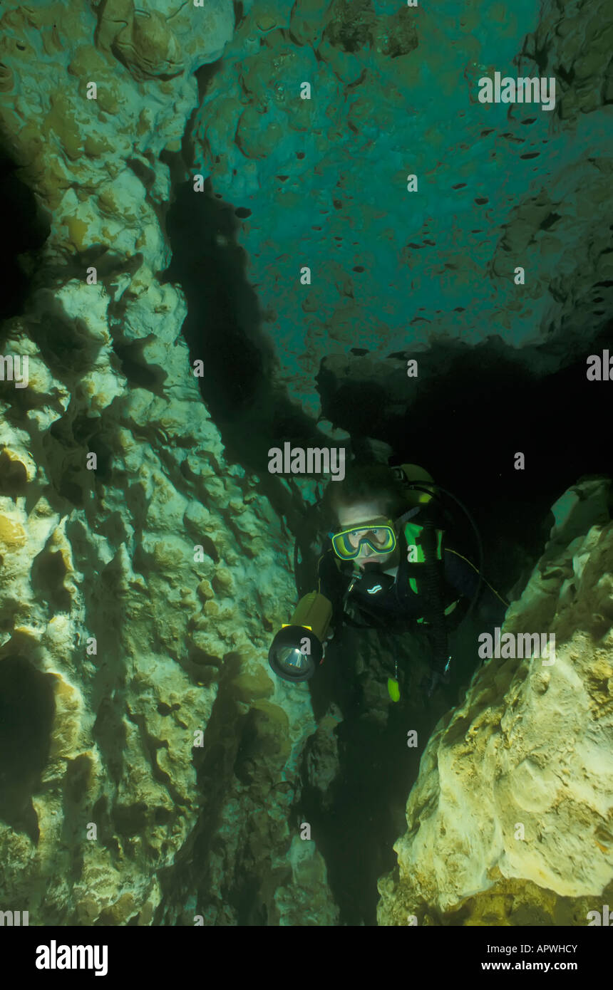 cave diver underwater surrounded by limestone walls at devils den, a Florida fresh water spring Stock Photo