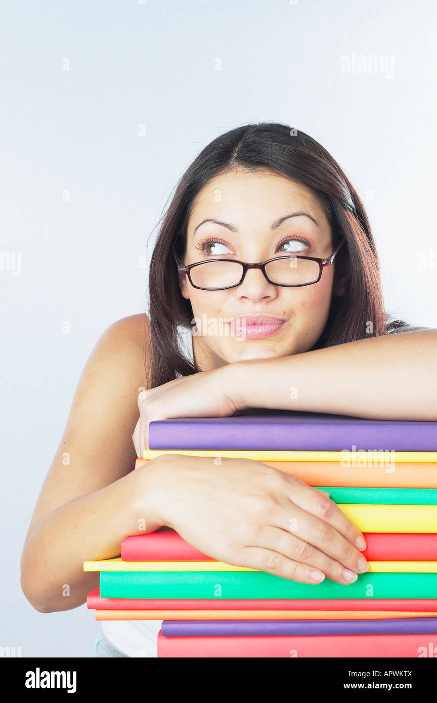Woman leaning on stack of books Stock Photo - Alamy