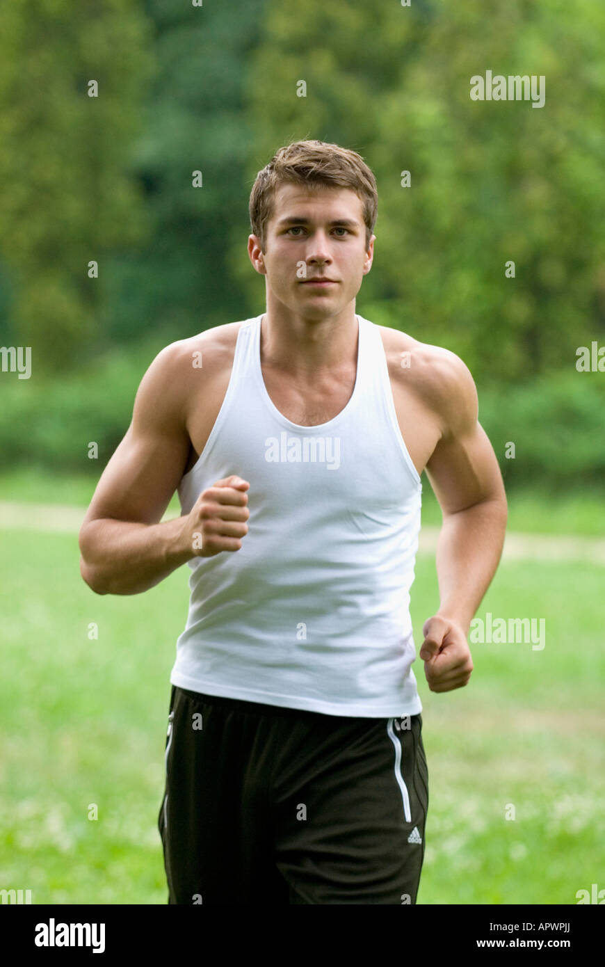 Jogging Portrait portrait of young man jogging through park Stock Photo - Alamy