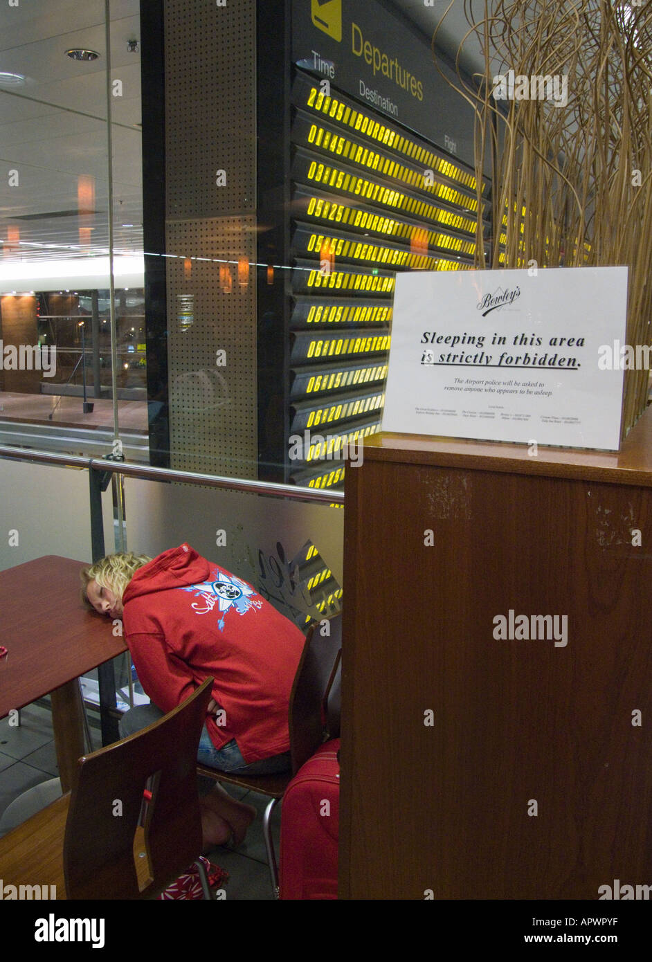 Dublin Airport  Ireland A passenger sleeps in a coffee shop in departures area of airport Stock Photo