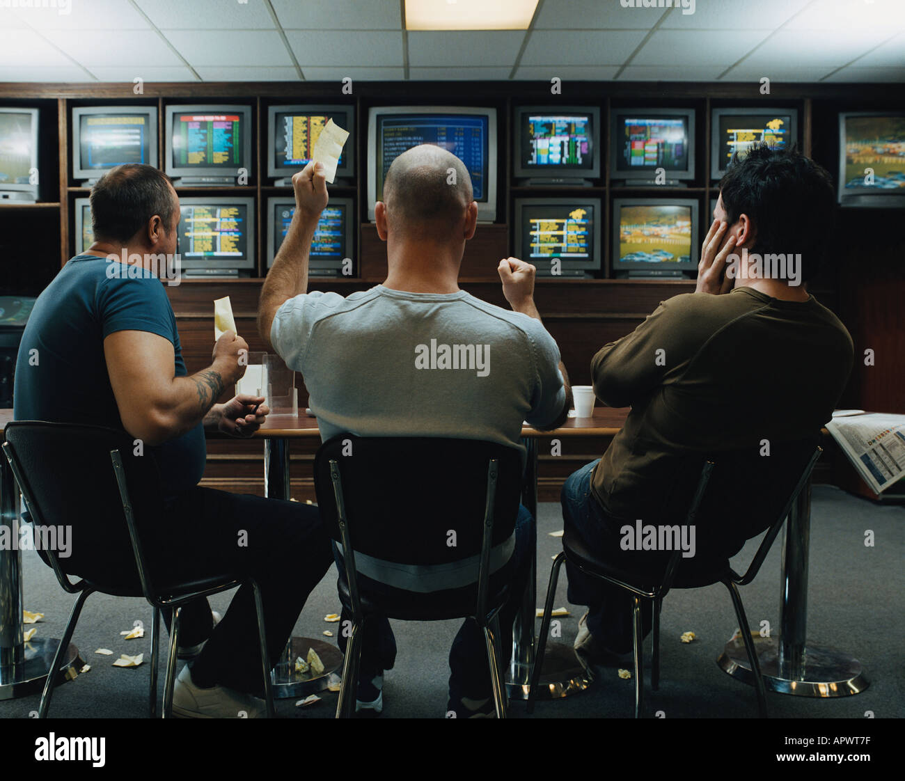 Three men in a betting shop Stock Photo