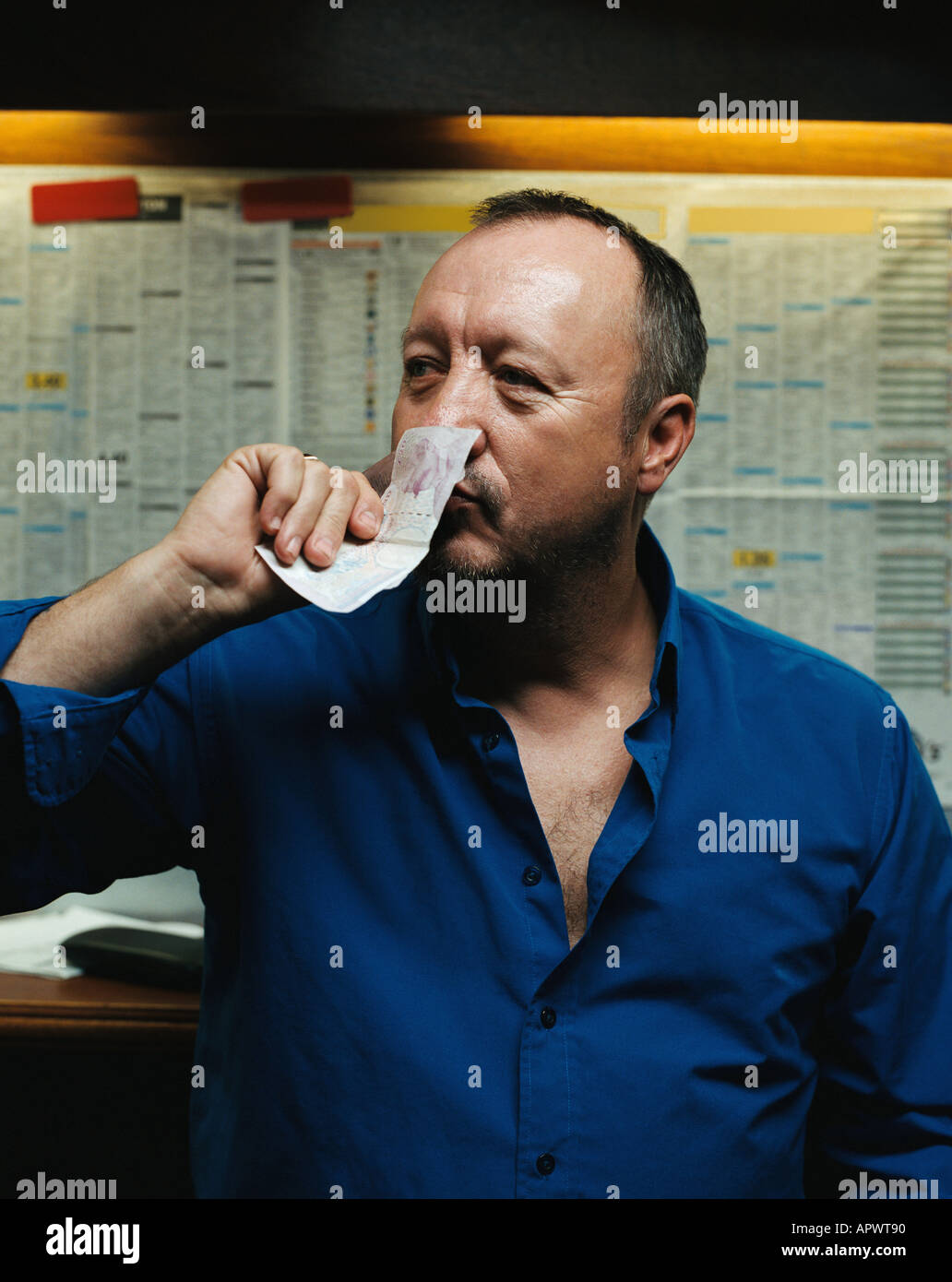 Man smelling a twenty pound note Stock Photo