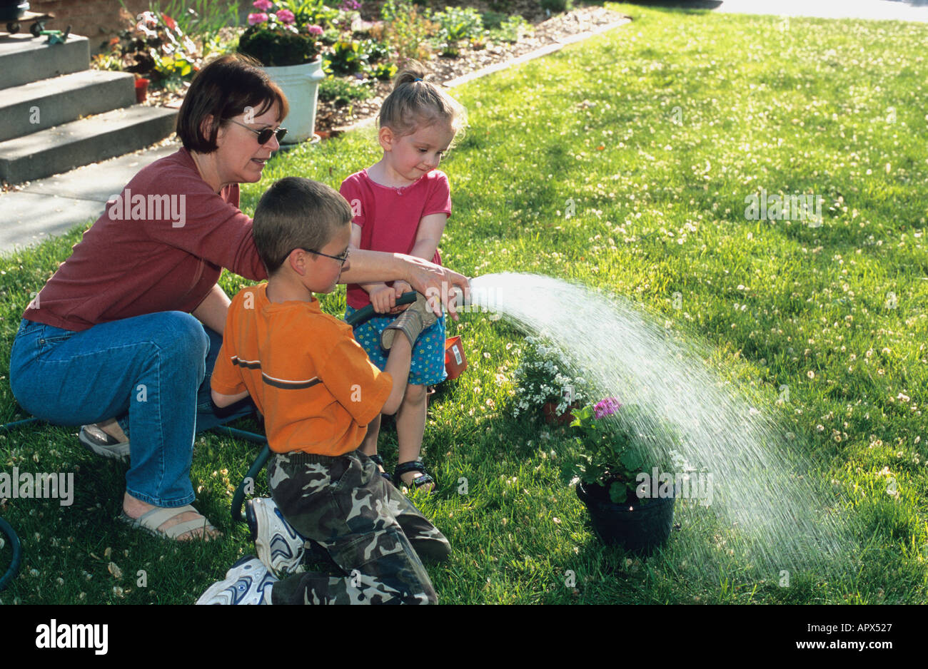 Girl and boy watering plants hi-res stock photography and images - Alamy