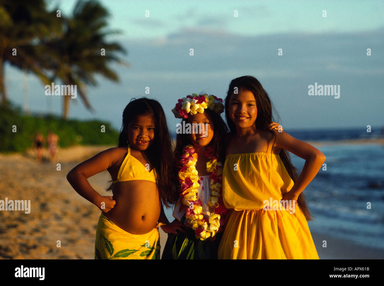 Three sisters pose for a portrait after finishing their hula lessons on the beach in Hawaii Stock Photo