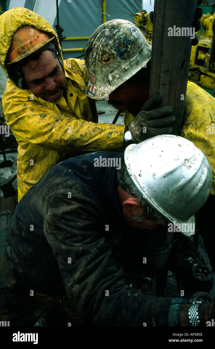 roughnecks changing a drill bit on the floor of an oil rig Stock Photo