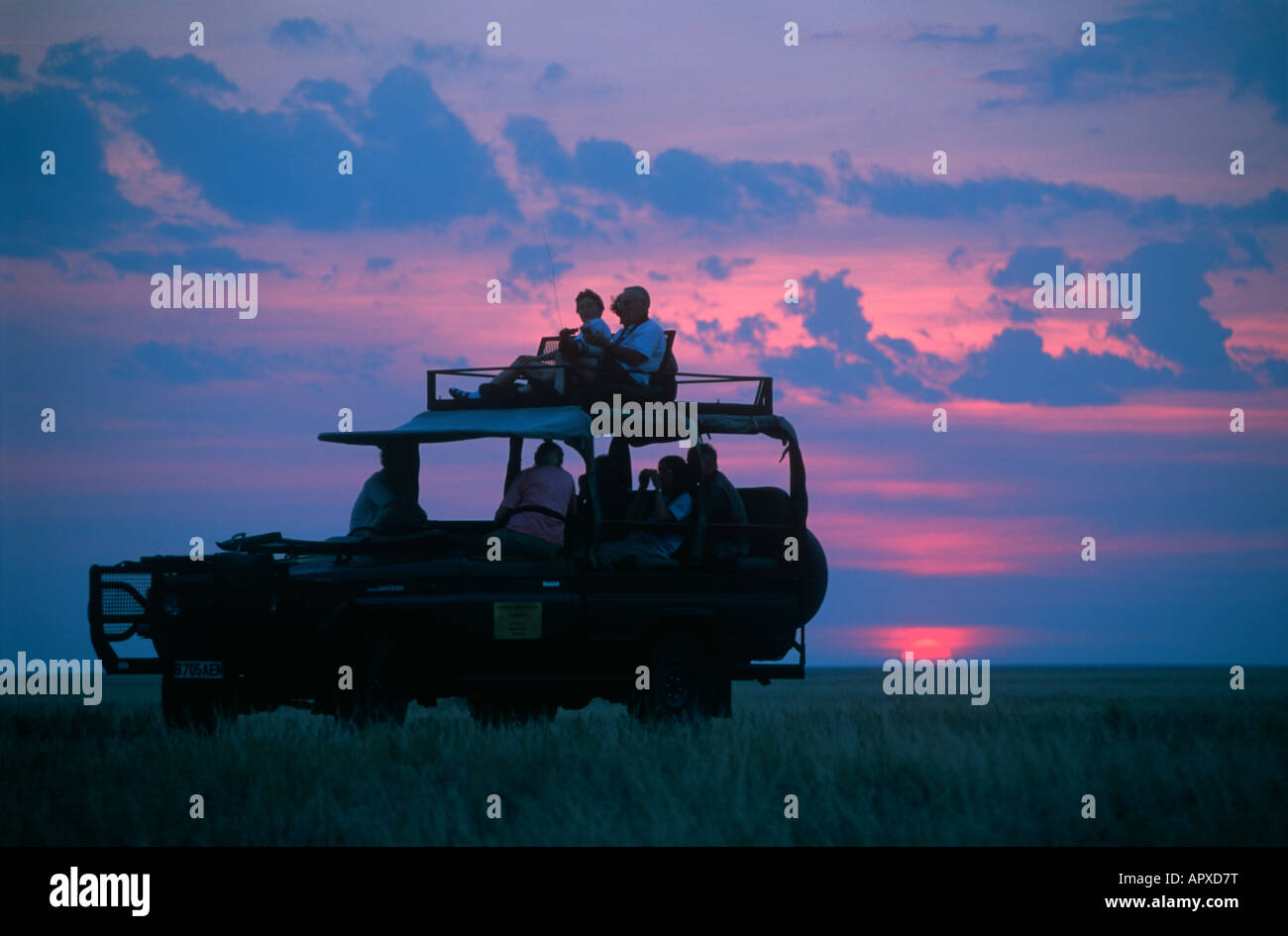 Sunset silhouette of a game-viewing vehicle and tourists on the Makgadikgadi Pans Stock Photo