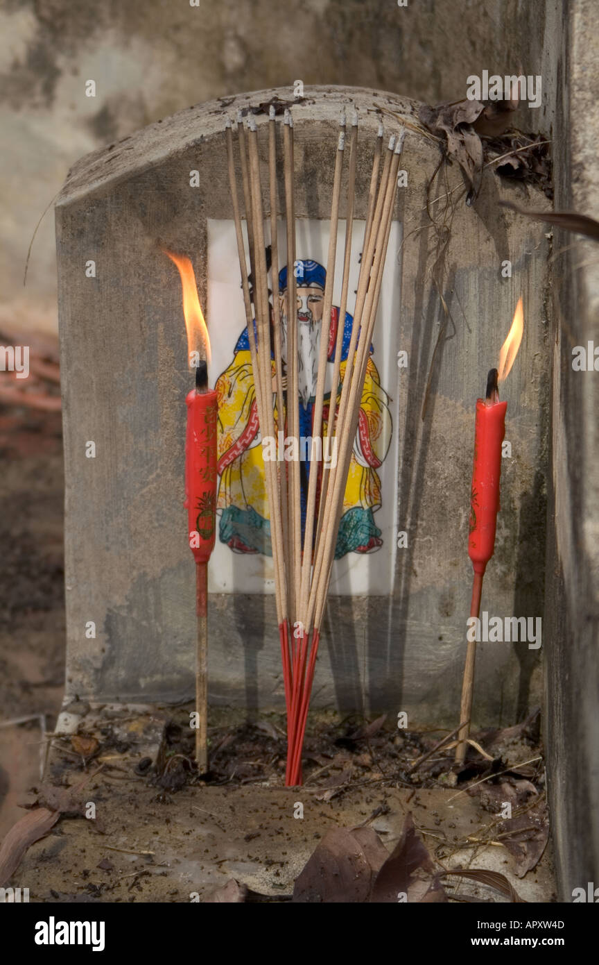 Lighted josticks in front of tomb stone at cemetery for Qing Ming Festival Malaysia, South East Asia Stock Photo