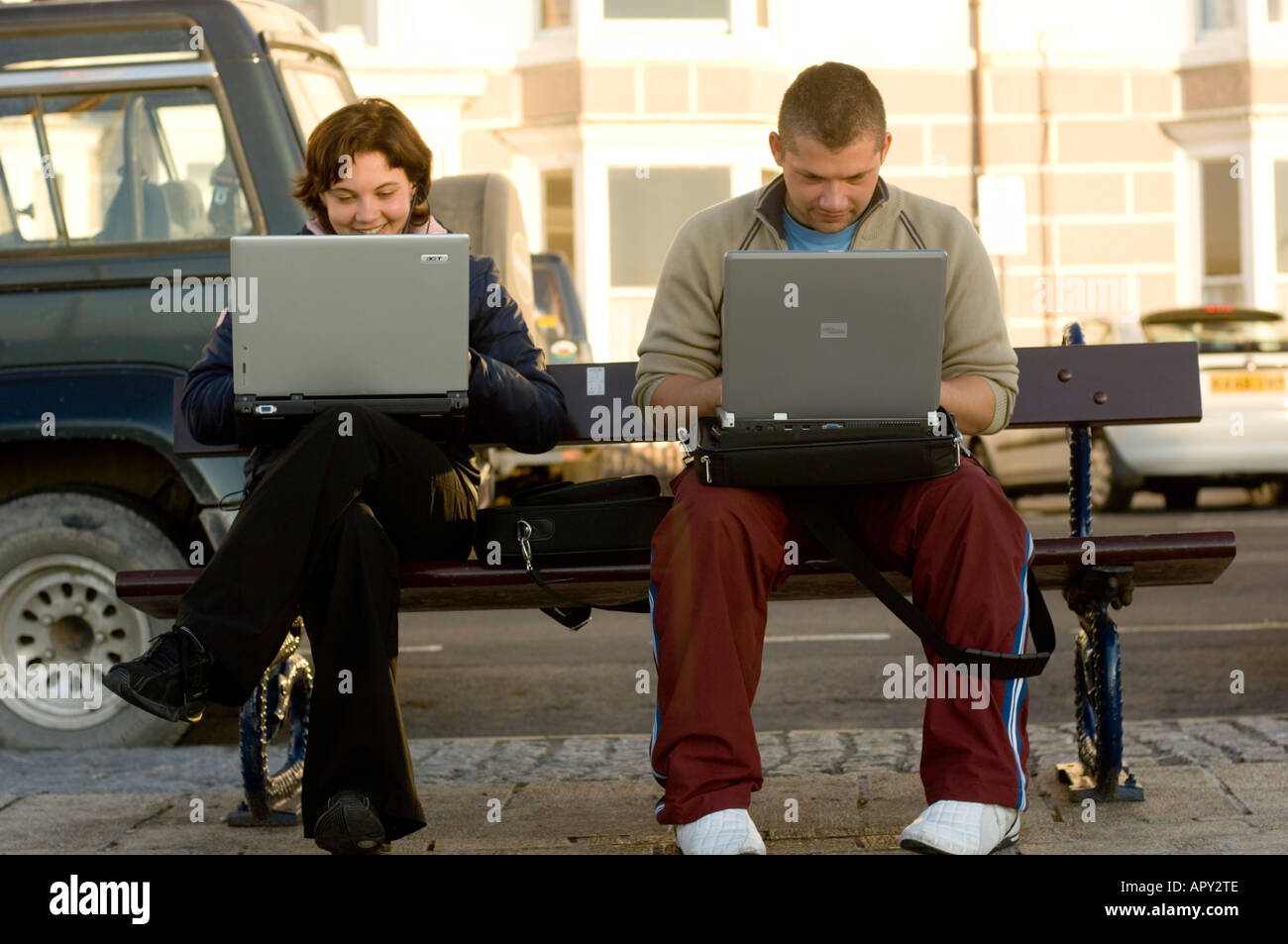 polish young people using laptops to access wireless network Aberystwyth promenade Stock Photo