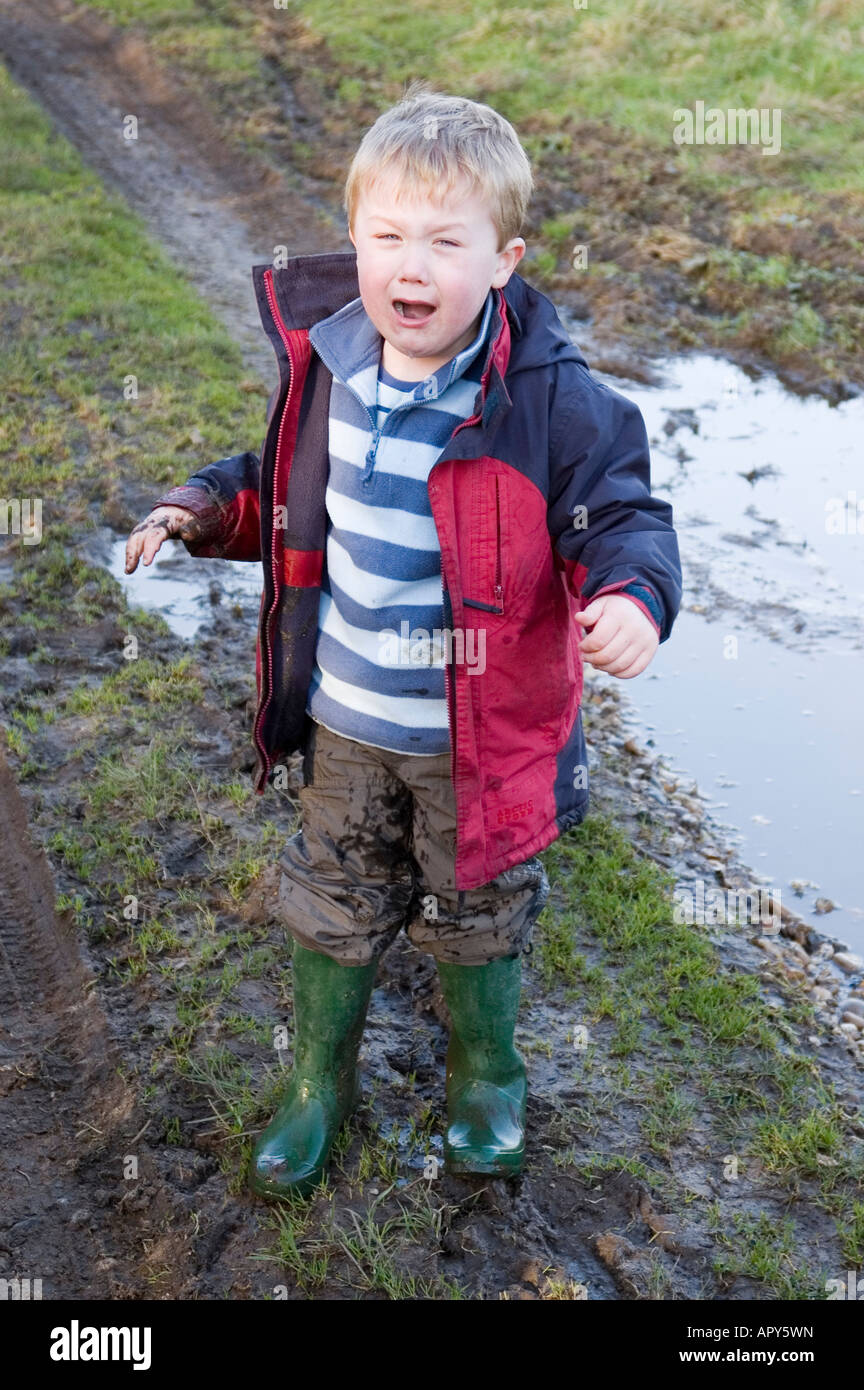 Four Year Old Boy Crying After Falling Over In Puddle in the uk countryside Stock Photo