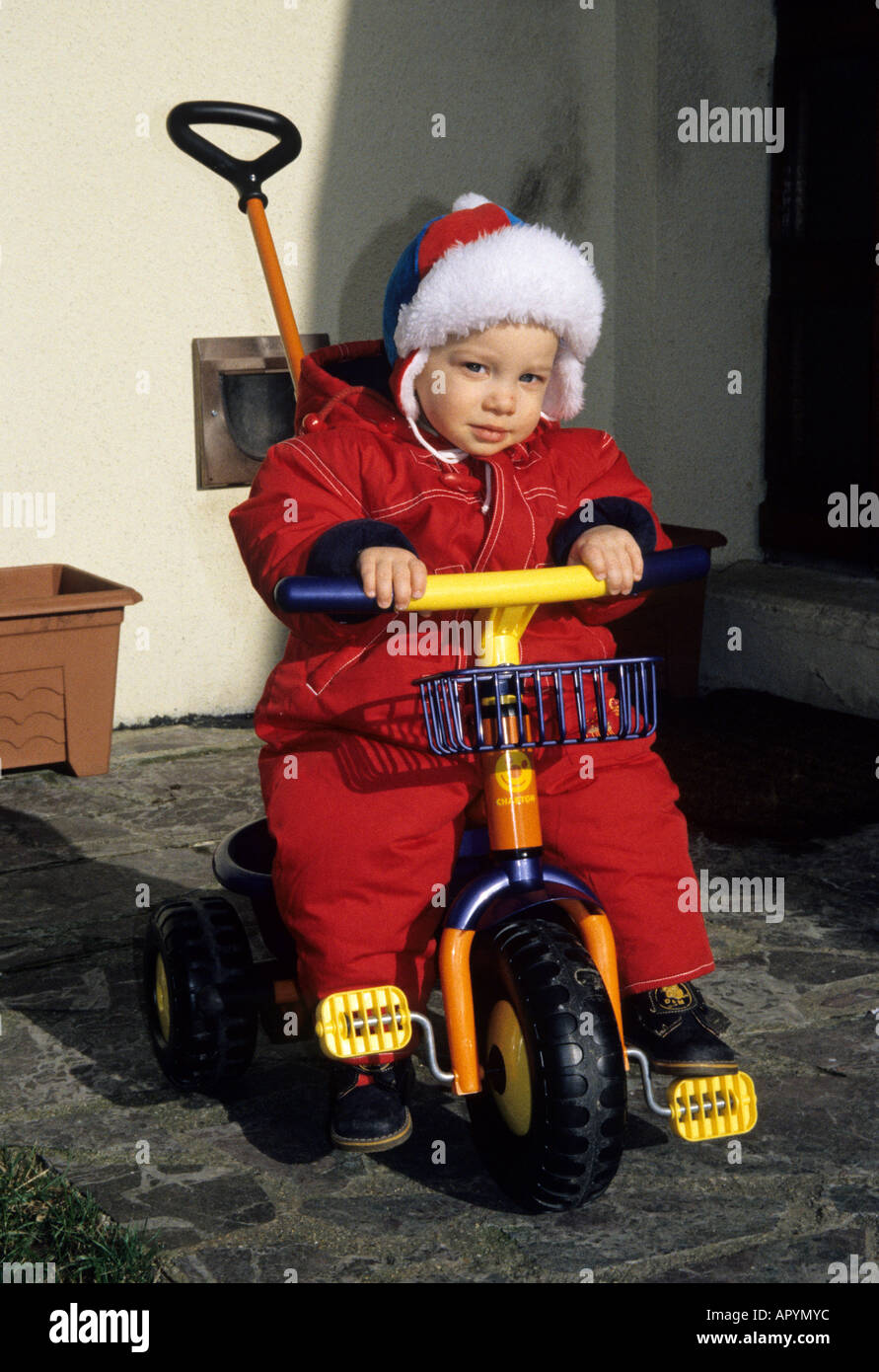Boy one years old driving a bicycle tricycle Stock Photo