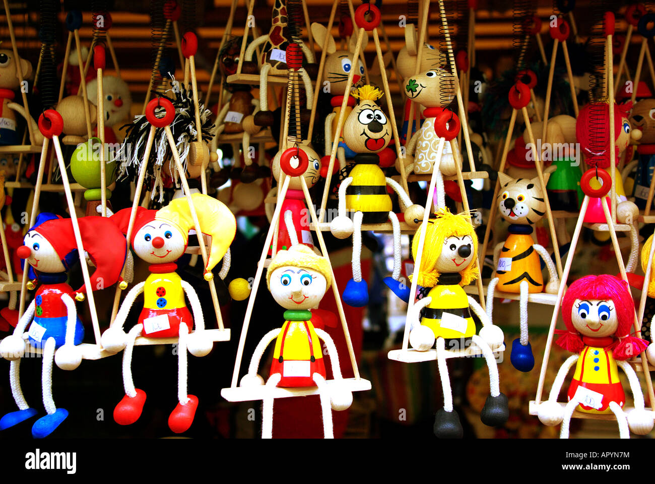 Wooden toys with rope arms and legs sitting on swings at Havelska