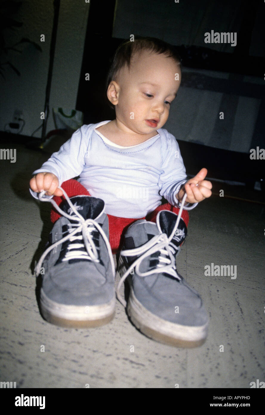 Boy one years old wearing huge shoes boots Stock Photo - Alamy