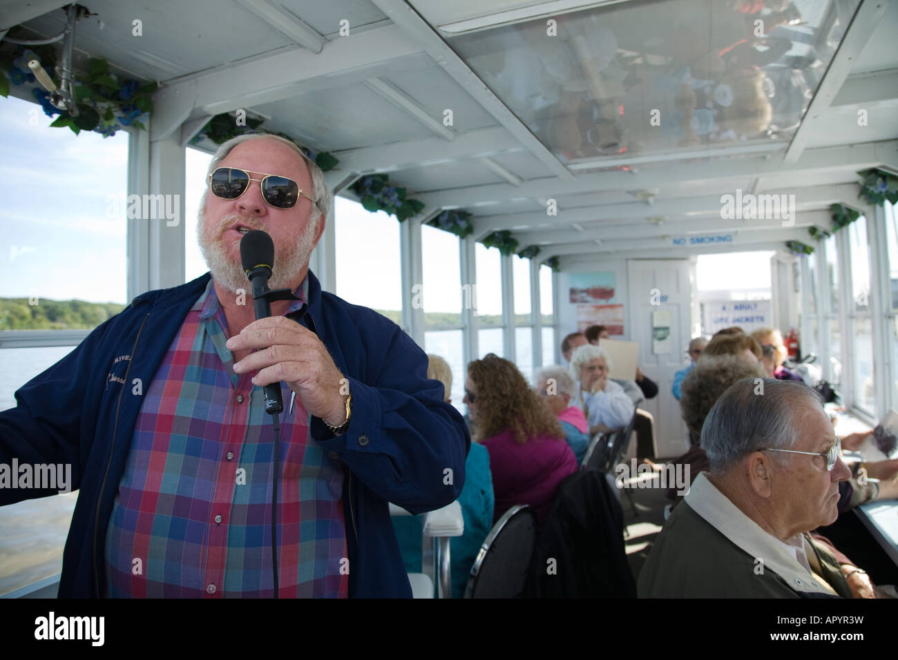 IOWA LeClaire Passengers on river tour boat looking out window captain narrating trip on Mississippi River with microphone Stock Photo