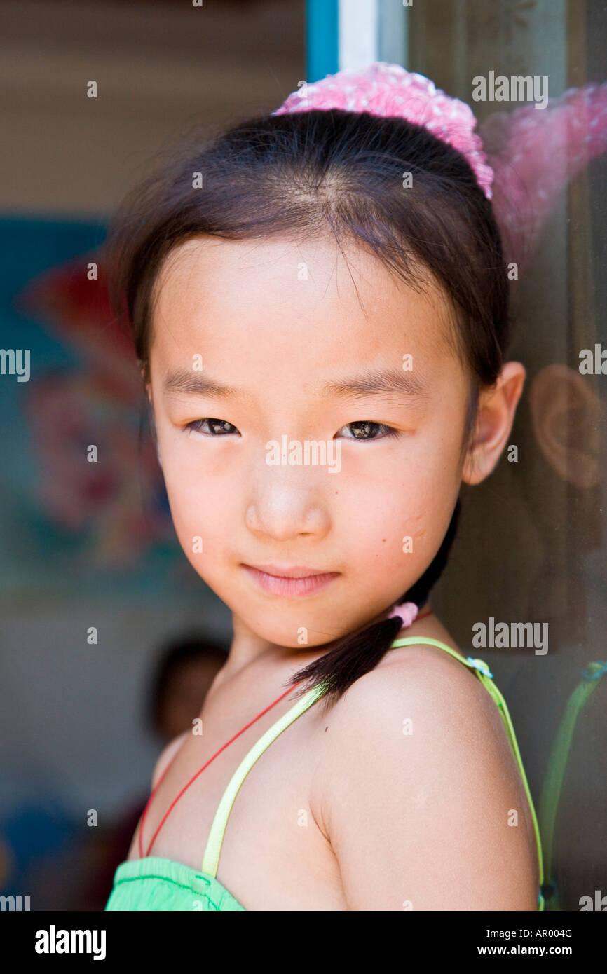Close up young asian oriental peasant Chinese girl in green dress ...