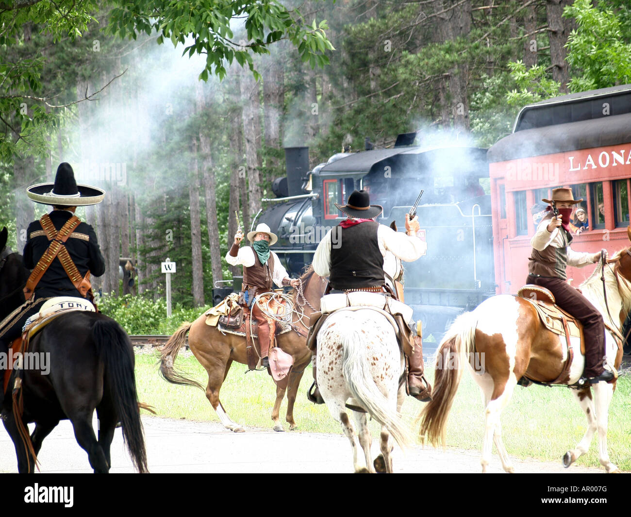 A gang of cowboy robbers robbing a steam engine train in the wilderness in Northern Wisconsin Stock Photo