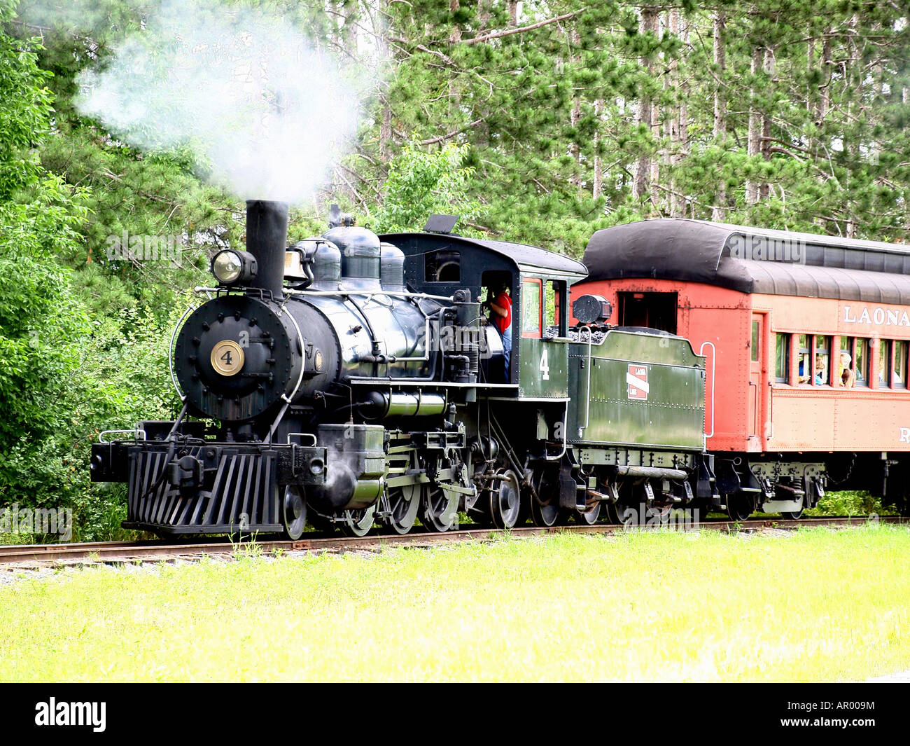 A Steam Engine 4 in Laona Wisconsin carrying passengers through the wooded landscape Stock Photo