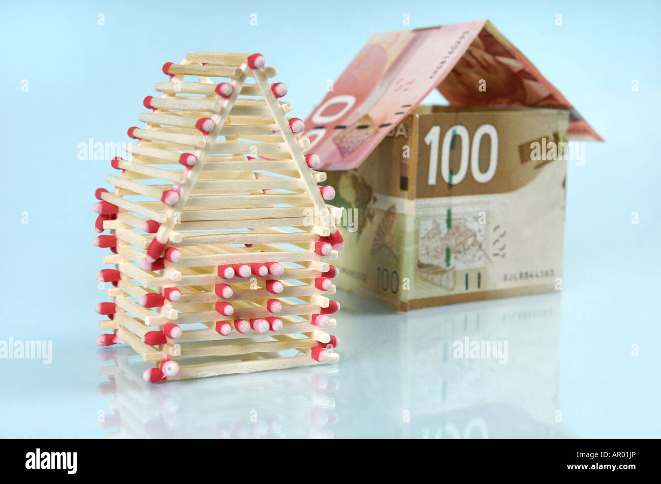 Family houses made from matches and Canadian dollar bills Stock Photo