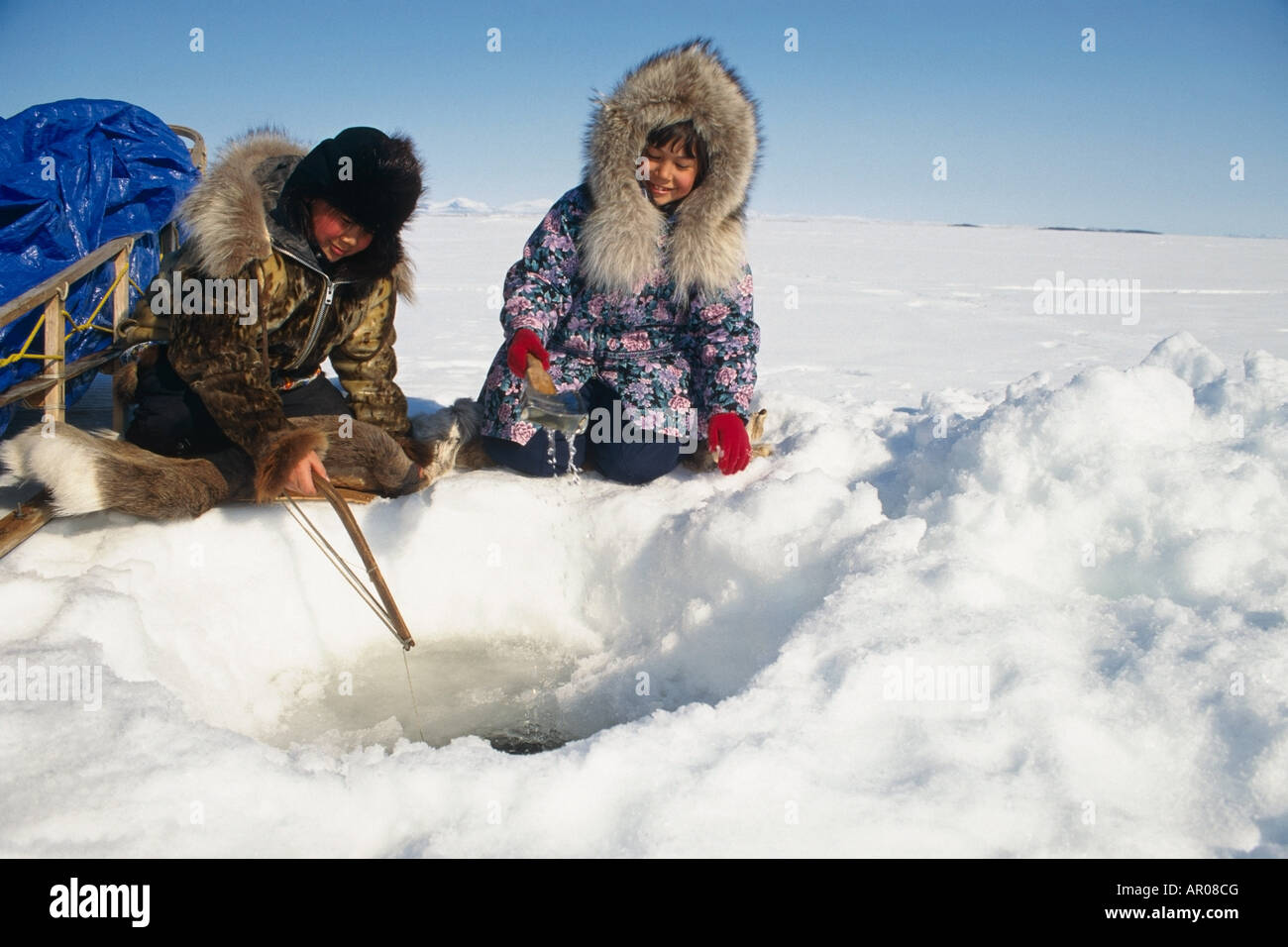 Natives Ice fishing in Kotzebue Western Alaska winter Stock Photo