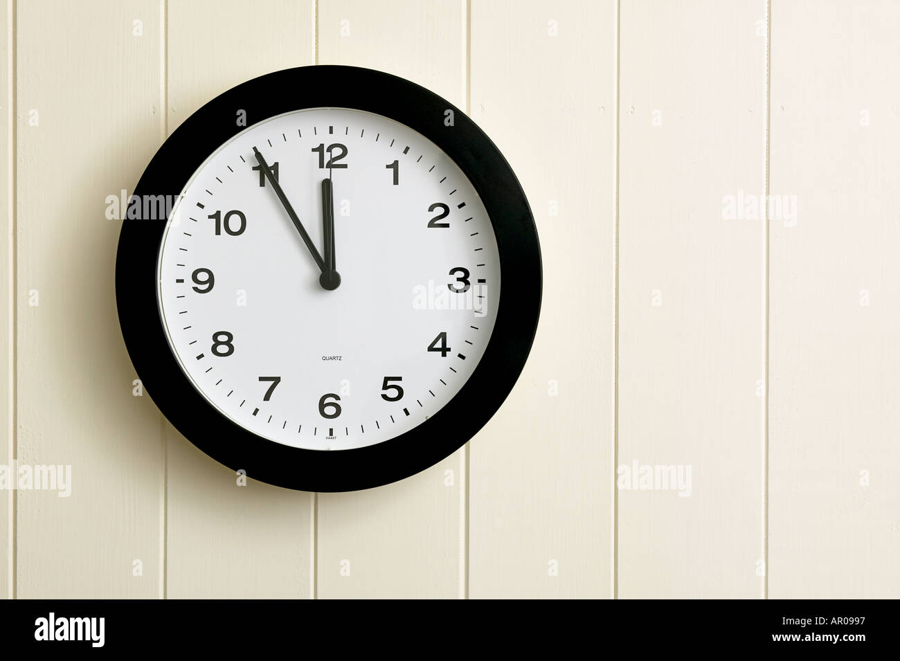 wall clock showing time at five to twelve 1155 2355