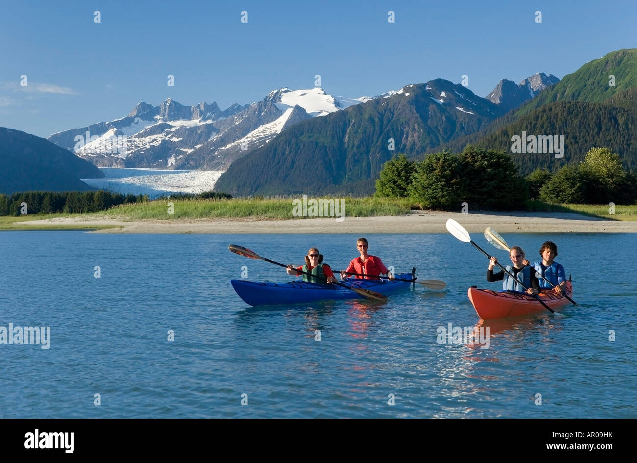 Kayakers kayaking in double sea-kayaks near Juneau in Inside Passage with view of Mendenhall Glacier Alaska Stock Photo